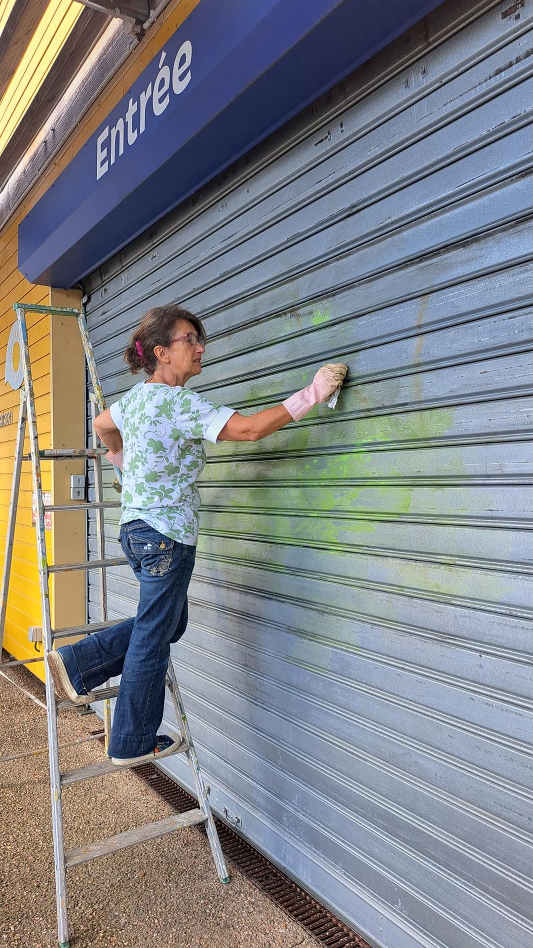 Une fresque en cours de création sur les rideaux de fer du magasin